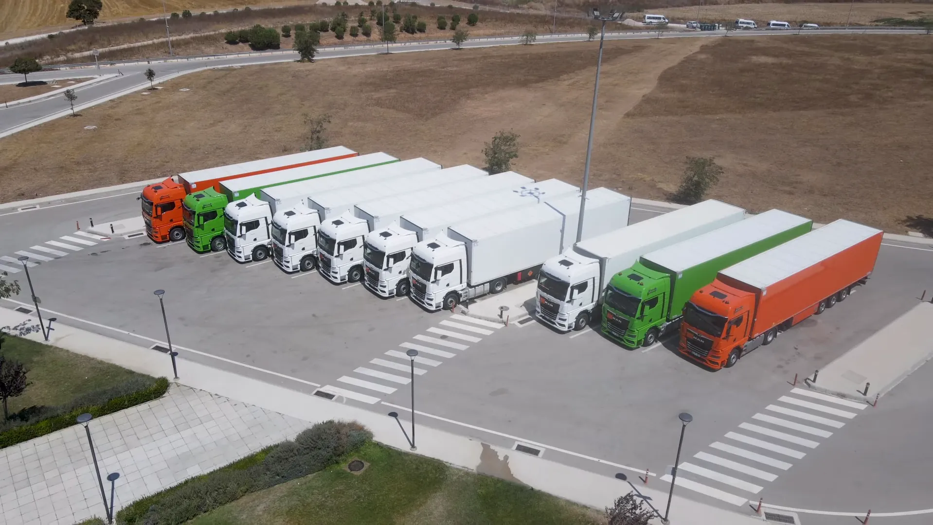 Dinlenme tesisinde yan yana park etmiş çekiciler, havadan görünüm